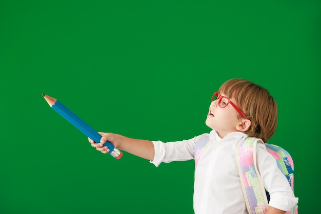 Foto glücklicher kinderstudent gegen grüne tafel