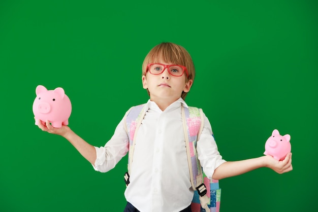 Glücklicher Kinderstudent gegen grüne Tafel