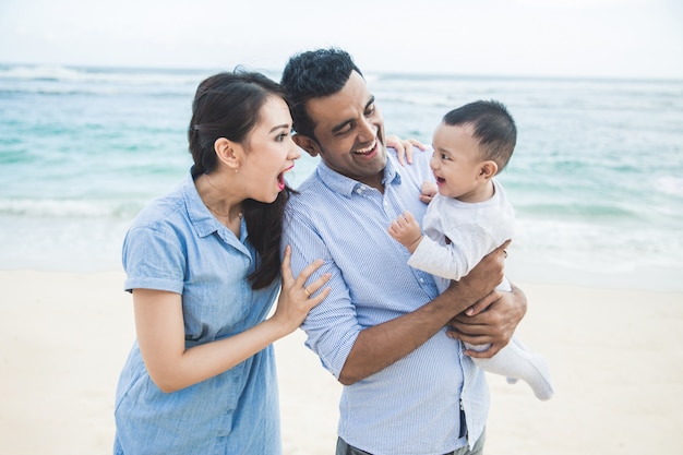 Glücklicher kleiner Familienurlaub am Strand