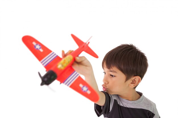 Glücklicher kleiner Junge, der mit Spielzeugflugzeug spielt