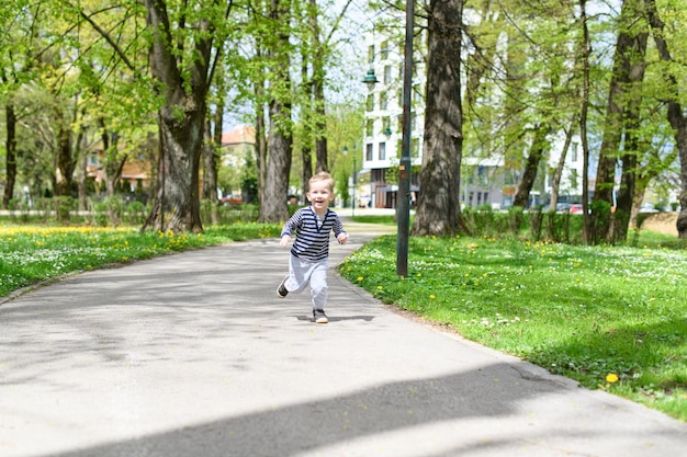 Glücklicher kleiner Junge, der Outoodrs im Park läuft