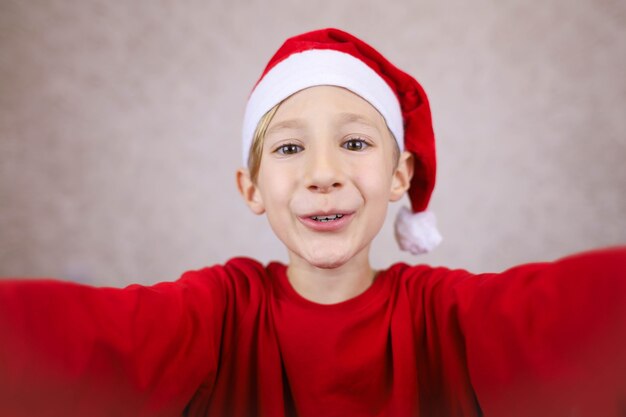 Glücklicher kleiner Junge mit Weihnachtsmütze