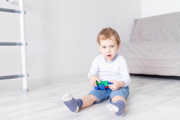 Glücklicher kleiner Junge spielt zu Hause mit einem Flugzeug