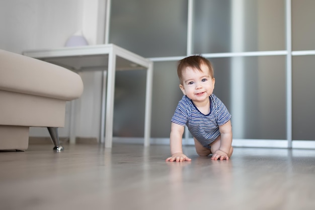 Glücklicher kriechender kleiner Junge zu Hause auf dem Boden