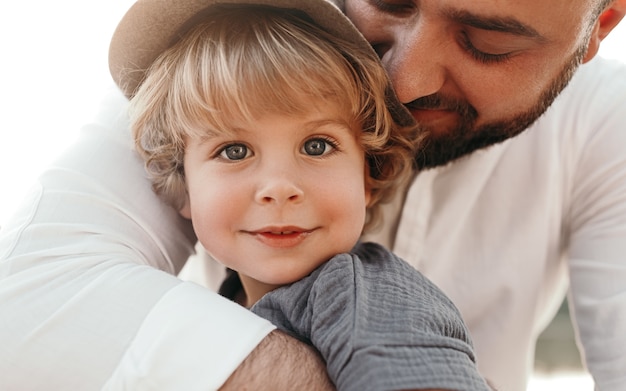 Foto glücklicher liebevoller vater, der kleines kind umarmt