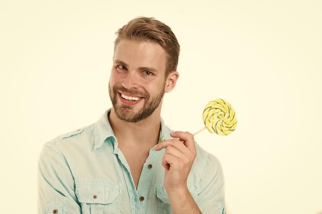 Glücklicher Macho mit Lollipop Man lächelt mit Süßigkeiten am Stick isoliert auf weißem Hintergrund Lebensmittel und Snacks Ungesunde Ernährung und Essen Lollipop-Spaß