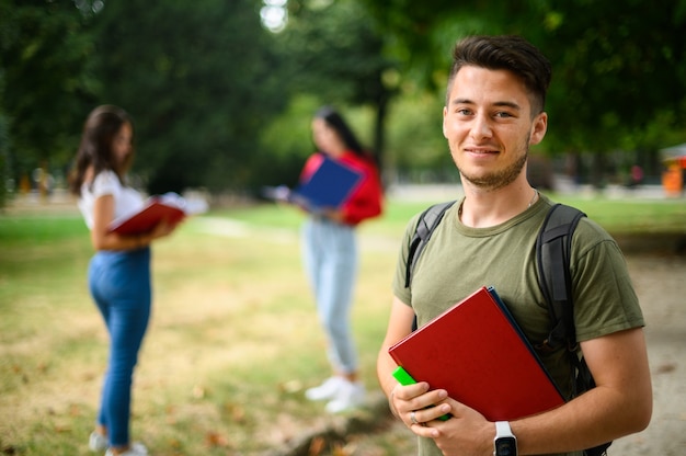 Glücklicher männlicher Student im Freien lächelnd