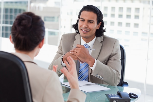 Glücklicher Manager, der einen weiblichen Bewerber interviewt