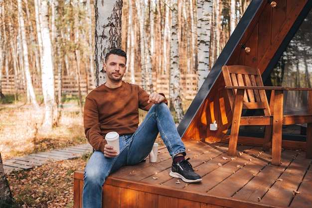 Glücklicher Mann auf der Terrasse im Herbst