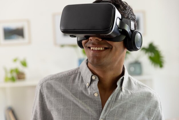 Glücklicher Mann aus zwei Rassen, der zu Hause ein VR-Headset benutzt