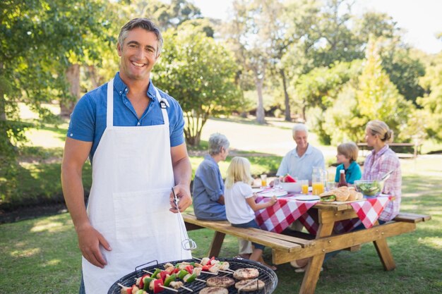 Glücklicher Mann, der Grill für seine Familie tut