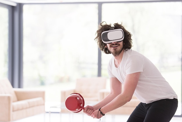 glücklicher Mann, der zu Hause Erfahrungen mit der VR-Headset-Brille der virtuellen Realität sammelt