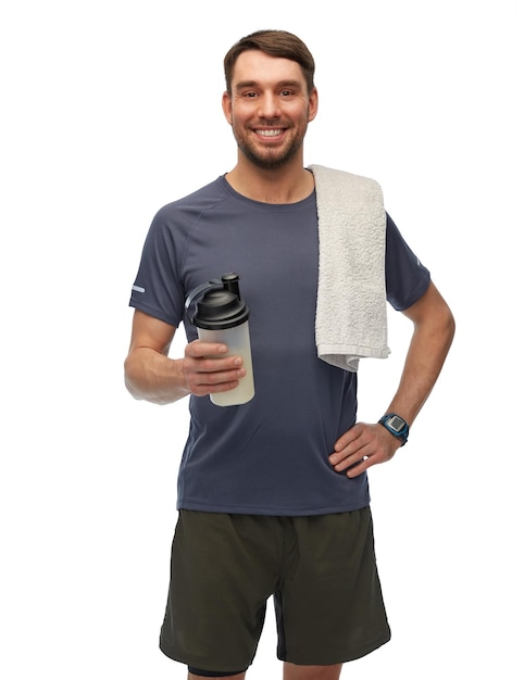 glücklicher Mann in Sportkleidung mit Flasche und Handtuch