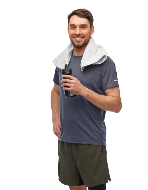 glücklicher Mann in Sportkleidung mit Flasche und Handtuch