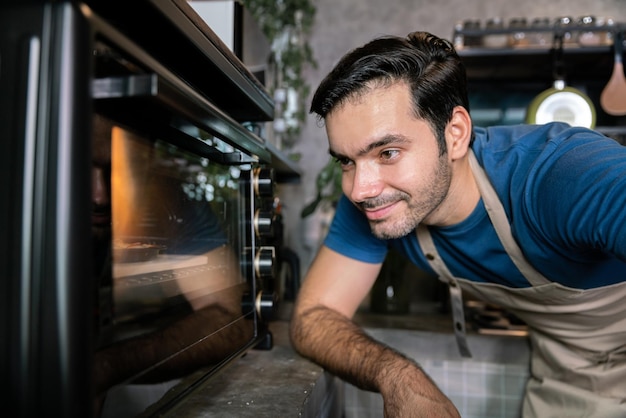 Glücklicher Mann Koch kocht und backt Pizzateig mit Ofenherd im italienischen Küchenrestaurant zum Abendessen