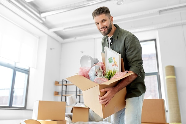 glücklicher Mann mit Kiste, der in ein neues Zuhause umzieht