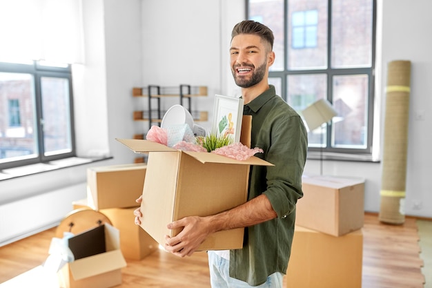 glücklicher Mann mit Kiste, der in ein neues Zuhause umzieht