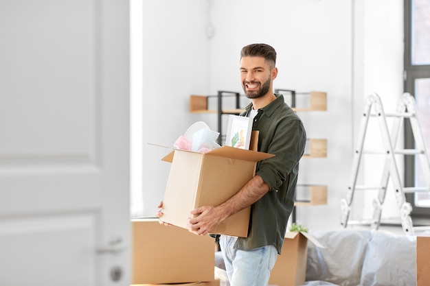 glücklicher Mann mit Kiste, der in ein neues Zuhause umzieht