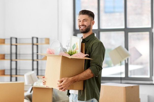 glücklicher Mann mit Kiste, der in ein neues Zuhause umzieht