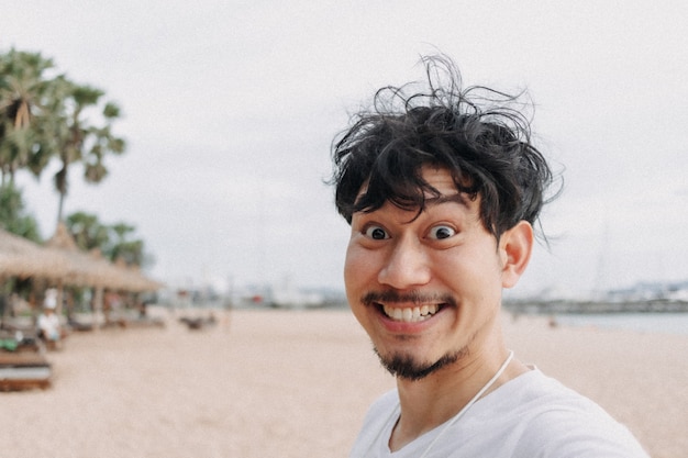 Glücklicher Mann selfie selbst entspannt auf dem Strandkonzept des Sommerurlaubs