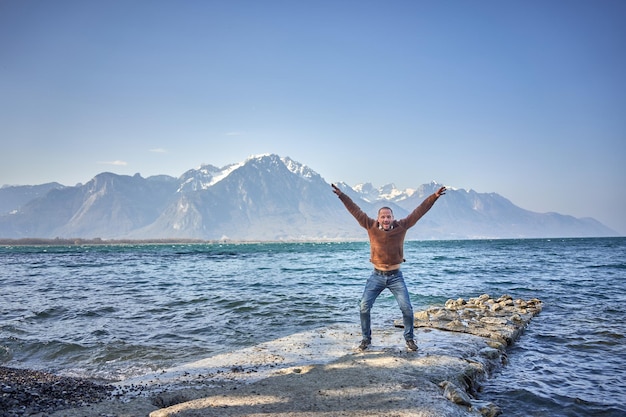 glücklicher mann springt am schweizer see in die luft