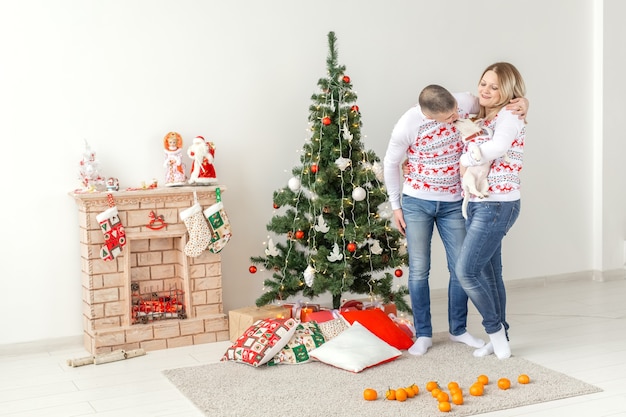 Glücklicher Mann und Frau nahe Weihnachtsbaum zu Hause