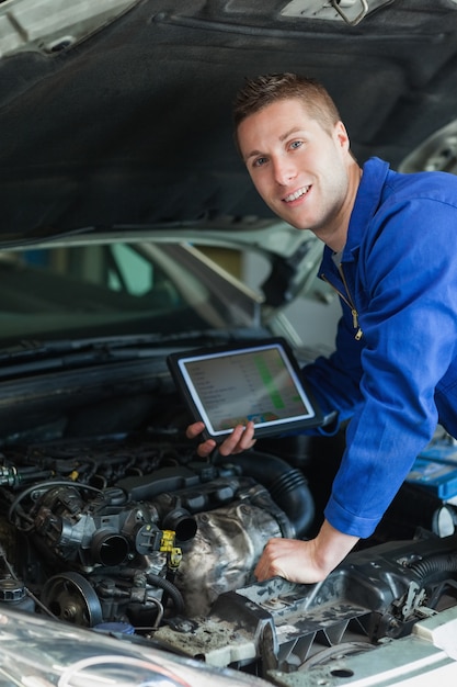 Glücklicher Mechaniker mit digitaler Tablette