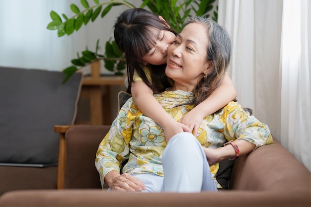 Glücklicher Moment der Tochter, die Zeit zusammen genießt und mit der Mutter zu Hause umarmt, kleines Mädchen, das Spaß hat