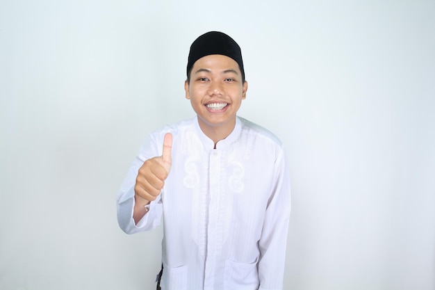 glücklicher muslimischer asiatischer mann, der die daumen nach oben gibt, isoliert auf weißem hintergrund