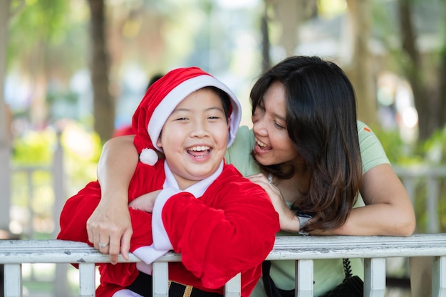 Glücklicher Mutter- und Sohnjunge, der Weihnachtsmann-Kostüm-Familienkonzept trägt