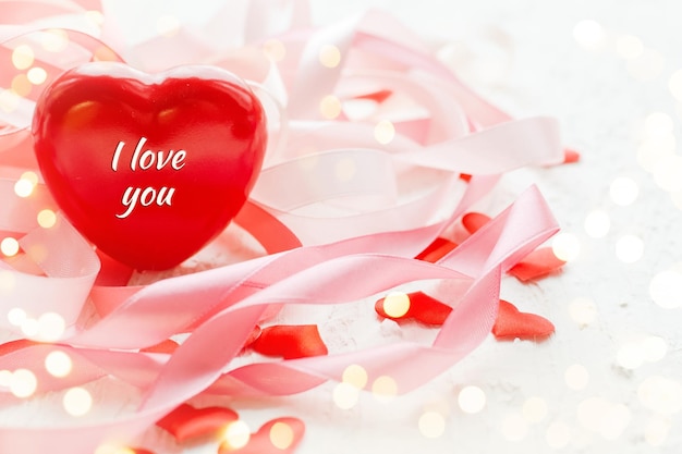 Glücklicher Muttertag oder Valentinstag Rotes Herz auf dem Hintergrund des verschwommenen Feiertagsbandes