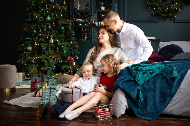 Glücklicher Muttervater und kleine Kinder genießen die gemeinsame Zeit an Feiertagen Frohe Weihnachten und ein gutes neues Jahr