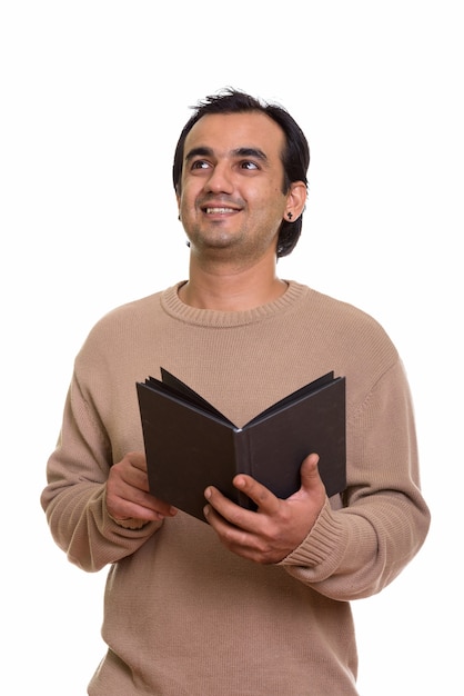glücklicher persischer Mann, der denkt, während Buch hält