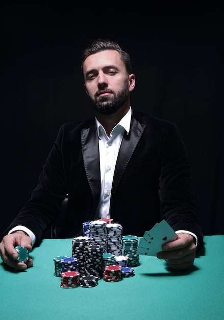 Glücklicher Pokerspieler, der gewinnt und ein Paar Asse hält