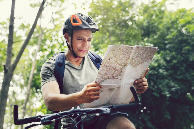 Foto glücklicher radfahrer, der durch den wald reitet