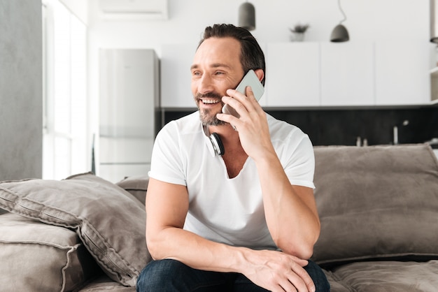 Glücklicher reifer Mann, der auf Handy spricht