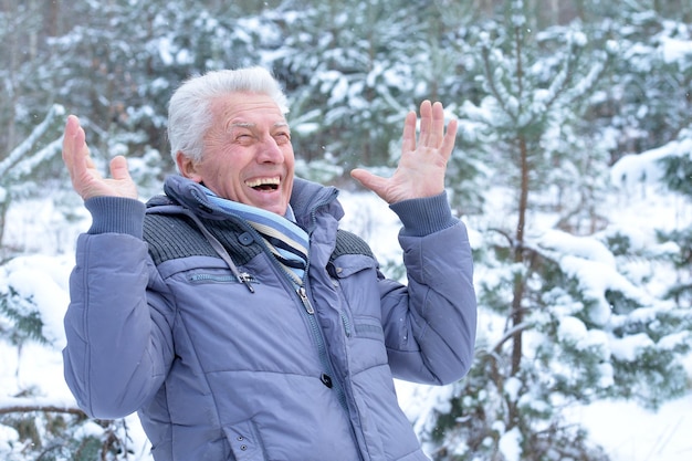 Glücklicher reifer Mann, der im Winter draußen aufwirft