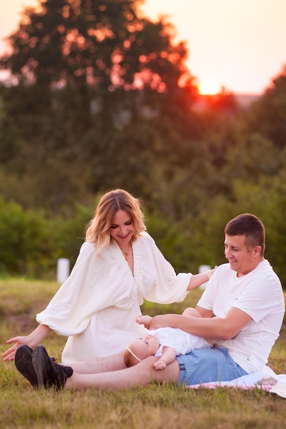 Glücklicher Sommertag der jungen Familie im Freien