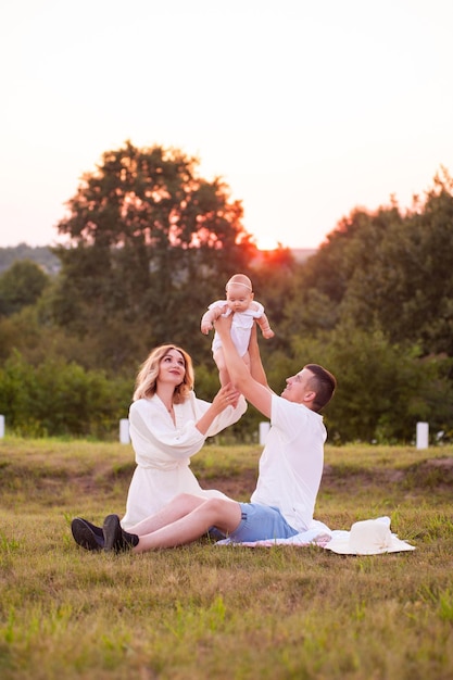 Glücklicher sommertag der jungen familie im freien