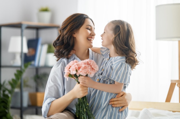 Glücklicher Tag Die Tochter des Kindes gratuliert der Mutter und schenkt ihr Blumen