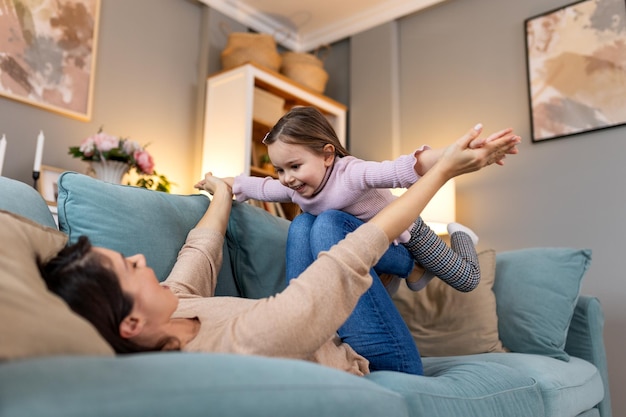 Glücklicher Tag Mutter und ihre Tochter Kind Mädchen spielen lächelnd und umarmen Familienfeiertag und Zusammenhalt