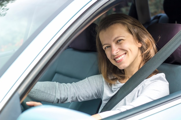 Glücklicher Treiber der jungen Frau sitzt im Auto.