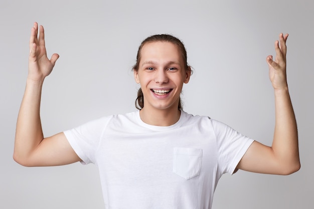 Glücklicher überraschter junger gutaussehender Mann im T-Shirt