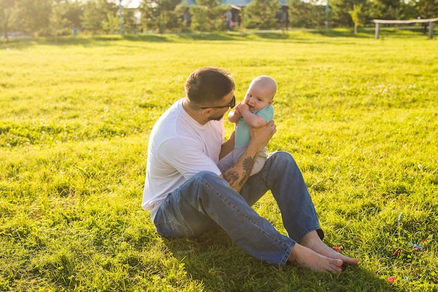 Glücklicher Vater, der Babysohn auf Naturkonzept des glücklichen Familienvaters Tag und des Kindes hält