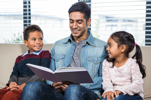 Glücklicher Vater, der ein Buch für seine Kinder liest