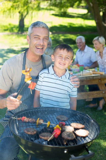 Foto glücklicher vater, der grill mit seinem sohn tut