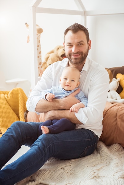 Glücklicher Vater, der kleinen kleinen Sohn hält. Vaterschaftskonzept