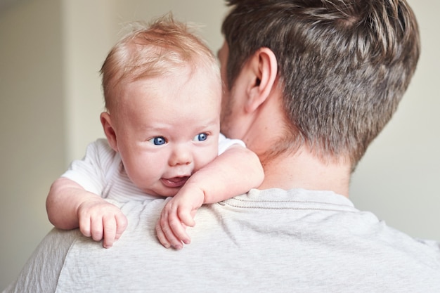 Glücklicher Vater, der neugeborenes Baby in seinen Armen hält. Am Vatertag