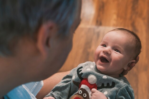 glücklicher Vater, der zu Hause mit kleinem Baby spielt