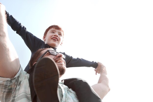 Glücklicher vater hält seinen sohn auf seinen schulterndas konzept der vaterschaft